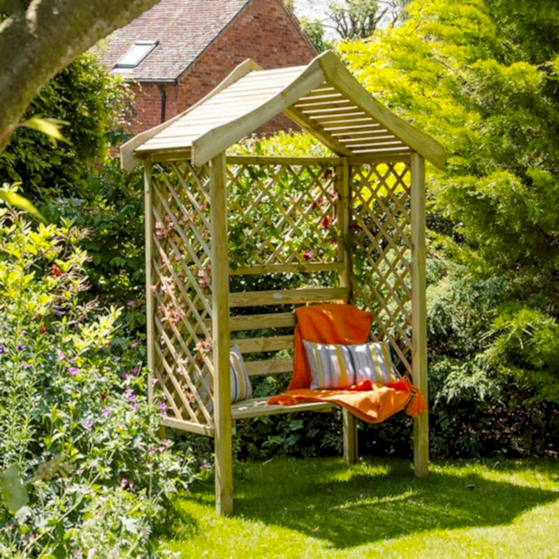 A Forest Parisienne Garden Arbour Seat on a lawn, with slatted panels and a pitched roof