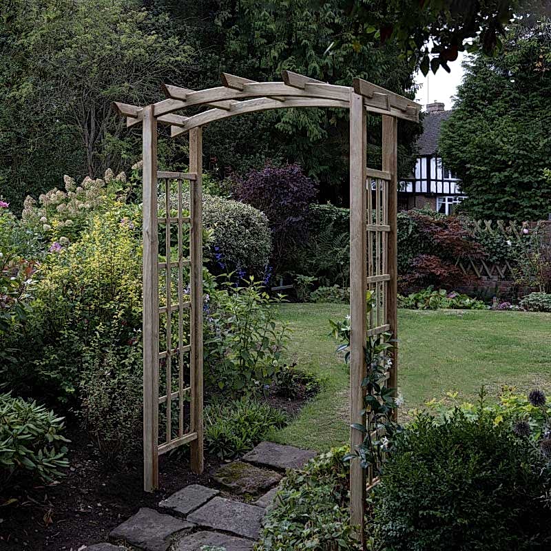 The Forest Classic Dome Top Wooden Garden Pergola Arch on a pathway with shrubs and lawn in the background