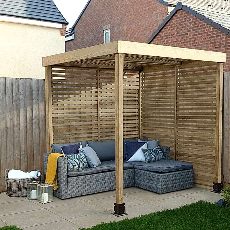 A Forest Modular Wooden Garden Pergola with two slatted sides and a garden corner sofa