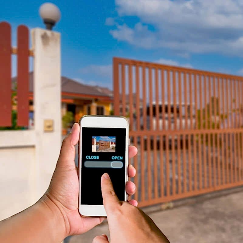 a photo of an automated metal driveway gate which is one of the gate types in our list of types of garden gates