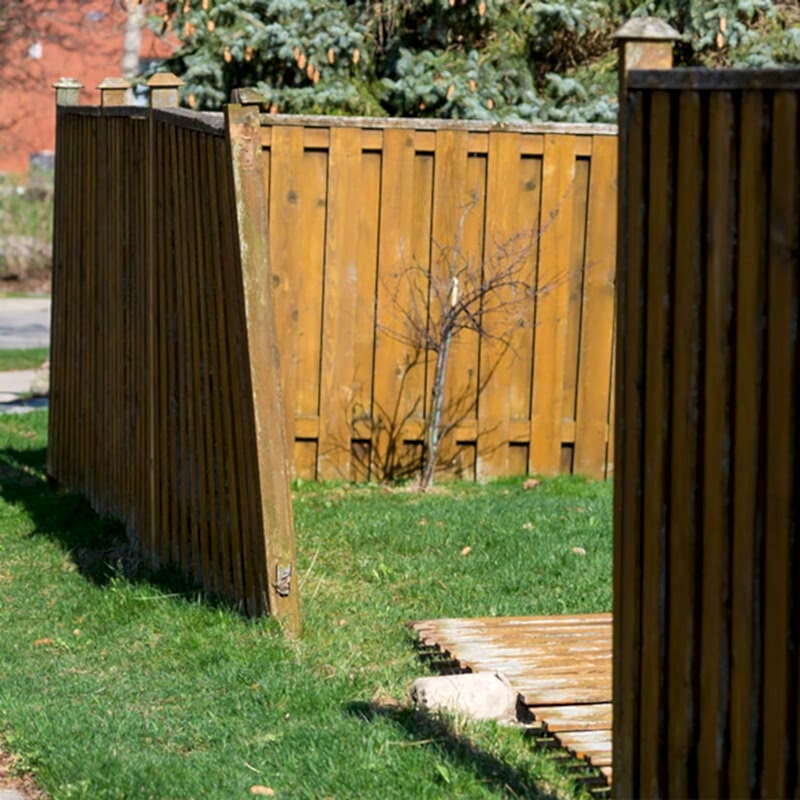 the owner of the damaged wooden fence in this photo will be wanting to learn to repair a wooden fence so will be desperately searching for how to repair a wooden fence or how to fix a broken fence
