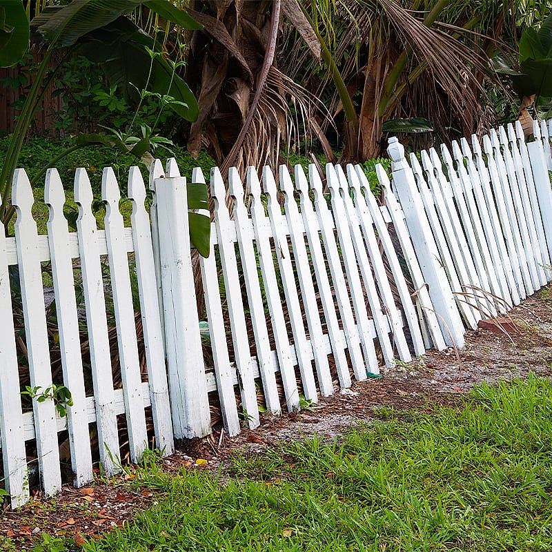 image of a white picket fence blown down in the wind