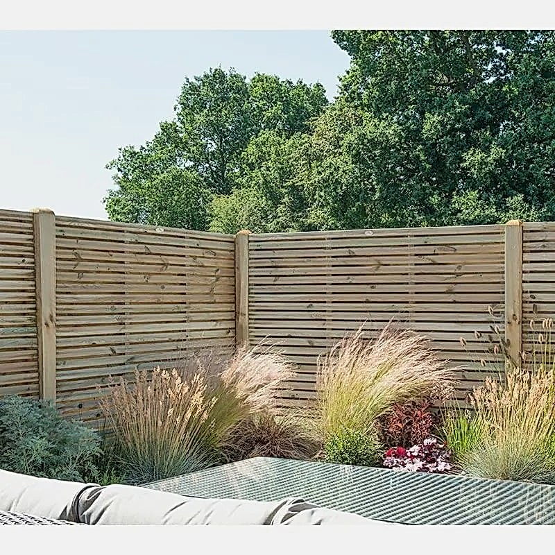 a photo showing a fencing run with some wonderful fence landscaping from our list of simple fence line landscaping ideas including the best plants for fence lines
