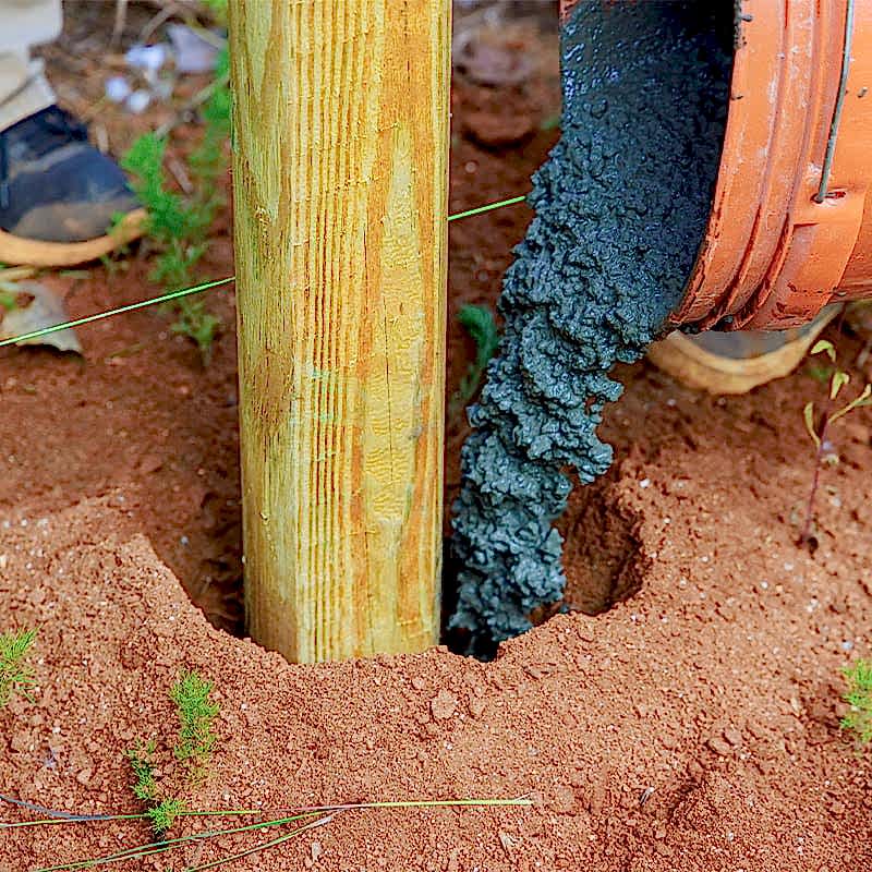 photo of someone installing a fence post
