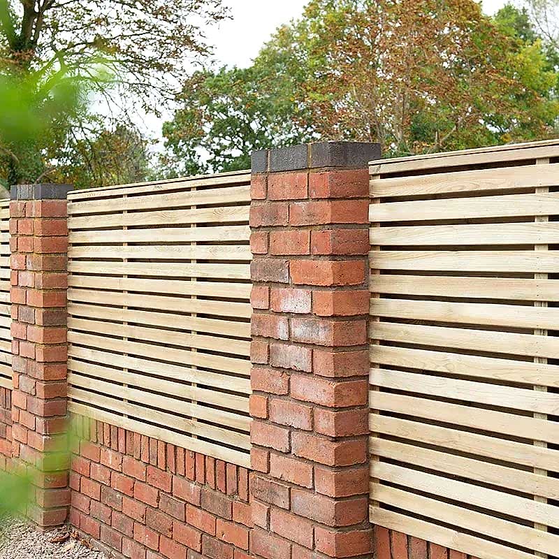 a wooden fence on top of a brick well is a great garden fence design