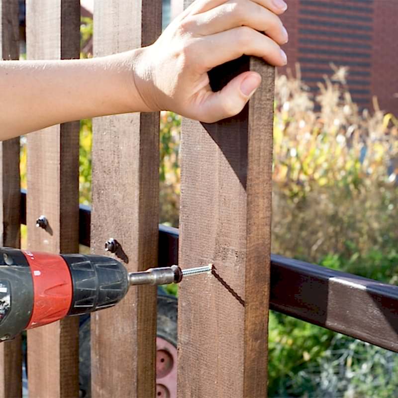 photo of someone installing a fence on a slope