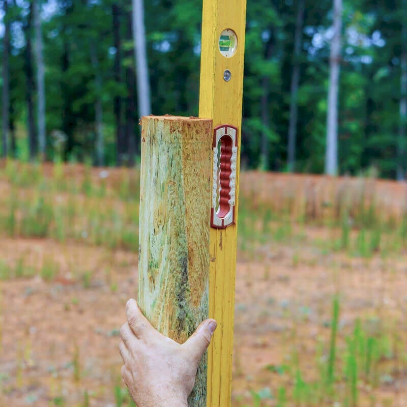 This image shows a stage in installing fence posts. To do this you will need to know how to install fence posts, how to install a fence post and how to set fence posts