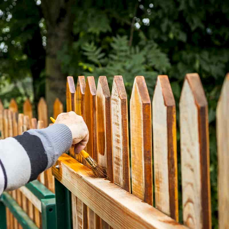 photo of someone staining their DIY Picket Fence
