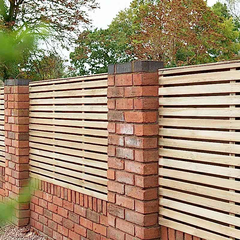 a photo showing a fencing run with some wonderful fence landscaping from our list of simple fence line landscaping ideas including the best plants for fence lines